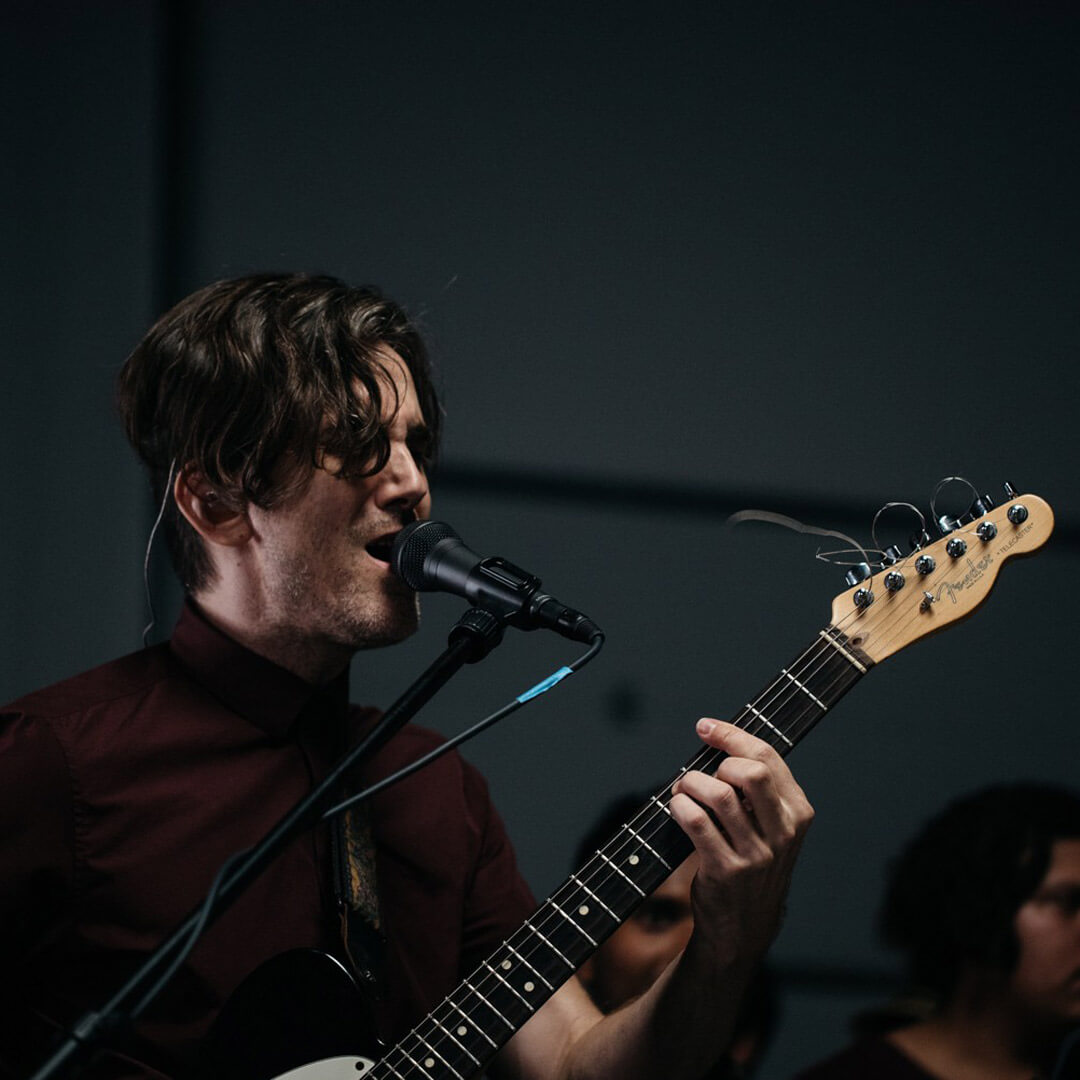 guitar player singing into microphone